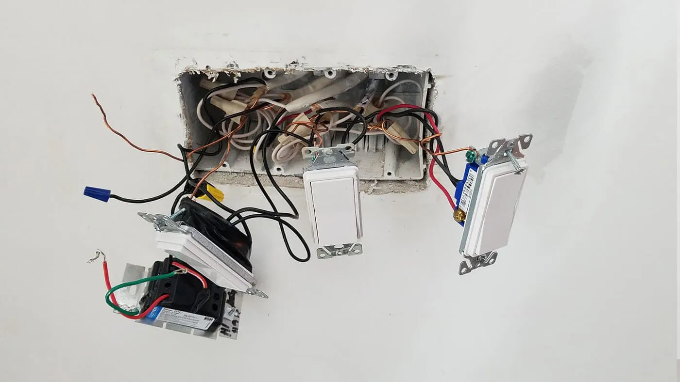 Exposed wiring hanging from an open switch box